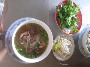 Noodles, fresh bean sprouts, thinly sliced beef, LOTS of fresh mint, scallions, coriander and sometimes unknowns. And one slice (for us) of really hot fresh chili.  Breakfast....or, lunch....or, dinner!